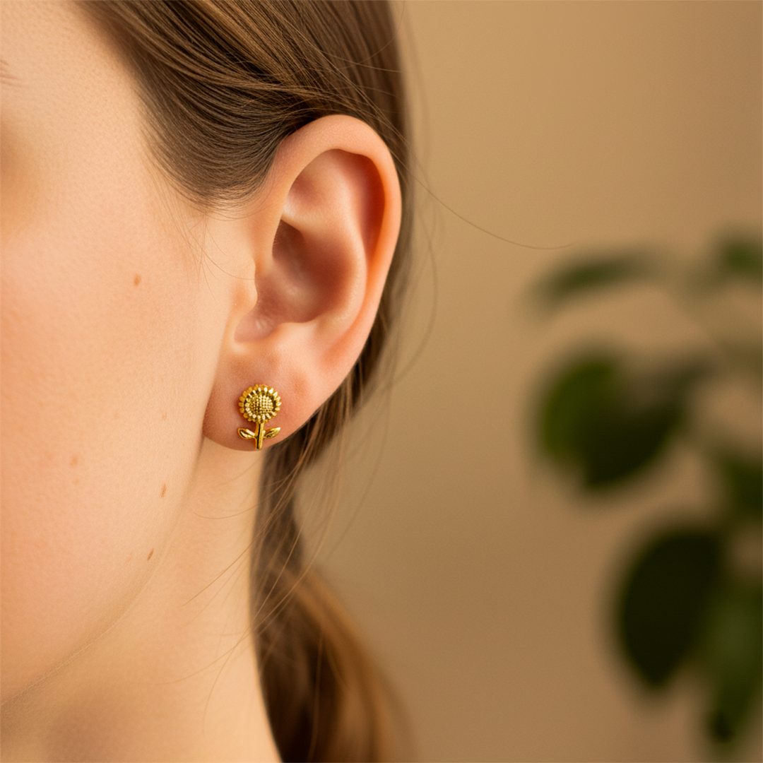 Oreja de modelo usando un topito en forma de girasol en oro amarillo de 18 quilates de Joyería Caracas. 