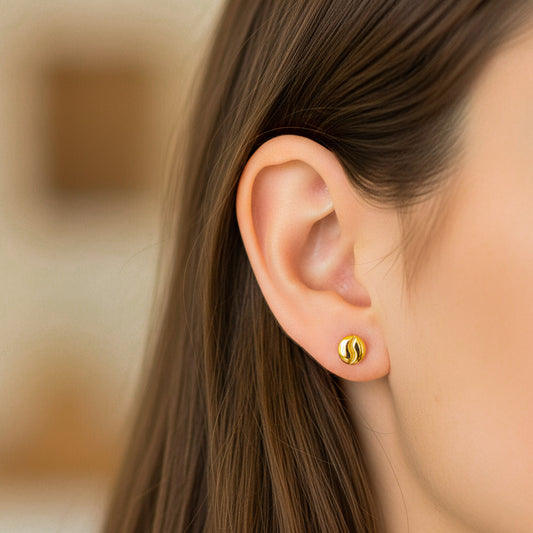 Oreja de modelo usando un topito en forma de grano de café en oro amarillo de 18 quilates de Joyería Caracas. 