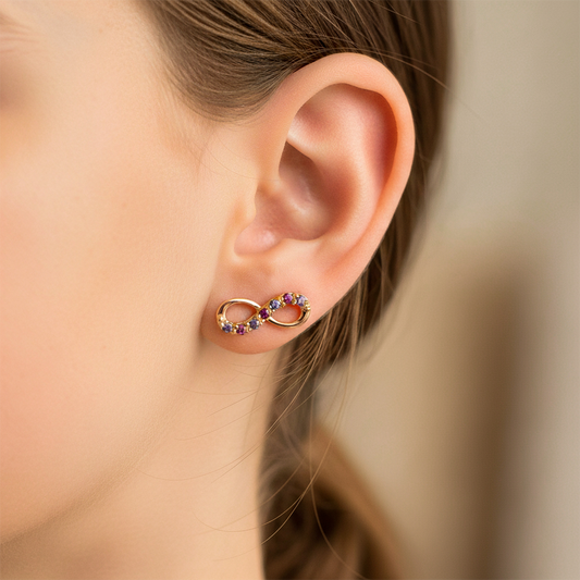 Oreja de modelo usando un topito en forma de infinito en oro rosa de 18 quilates con cristales de Joyería Caracas. 