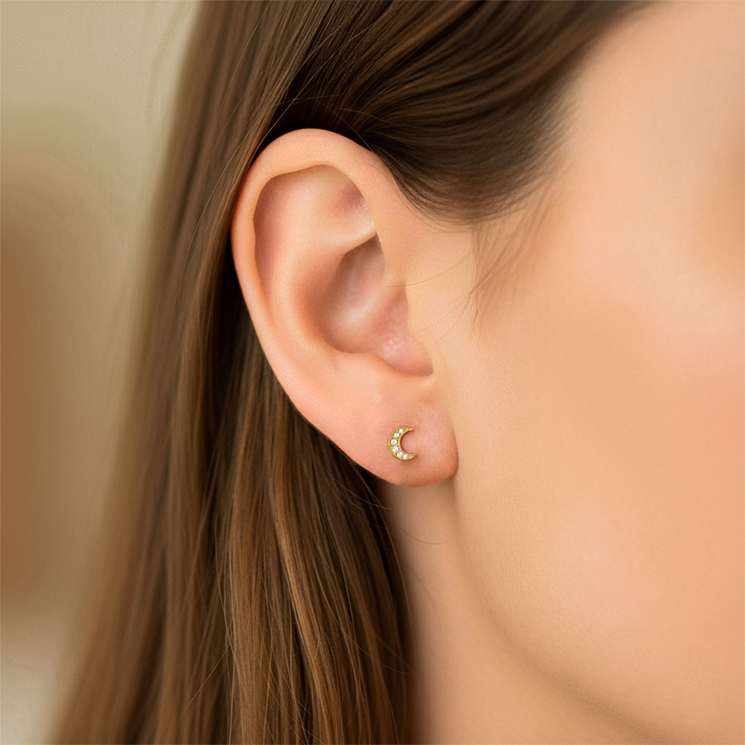 Oreja de modelo usando un topito en forma de luna en oro amarillo de 18 quilates de Joyería Caracas.