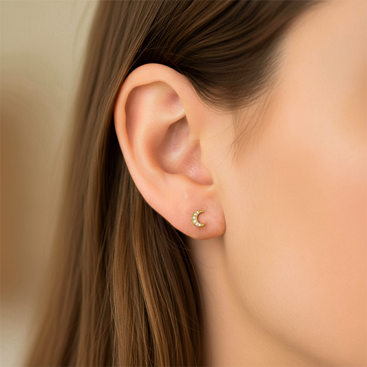 Oreja de modelo usando un topito en forma de luna en oro amarillo de 18 quilates de Joyería Caracas.