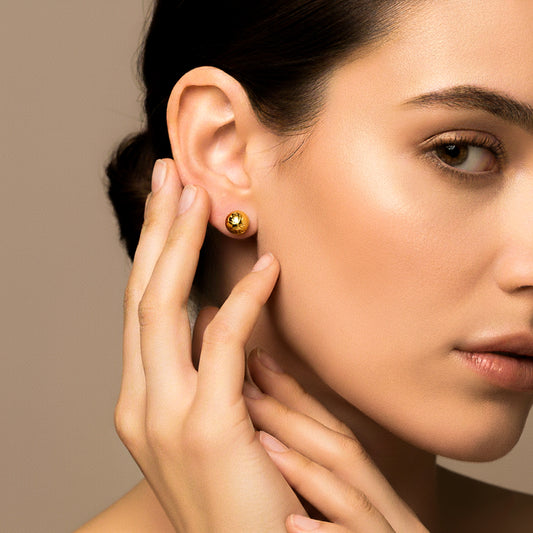 Oreja de modelo usando un topito de media esfera diamantada en oro amarillo de 18 quilates de Joyería Caracas. 