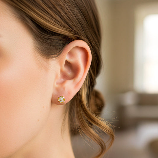 Oreja de modelo usando un topito circular en oro amarillo de 18 quilates con cristales de color blanco de Joyería Caracas. 