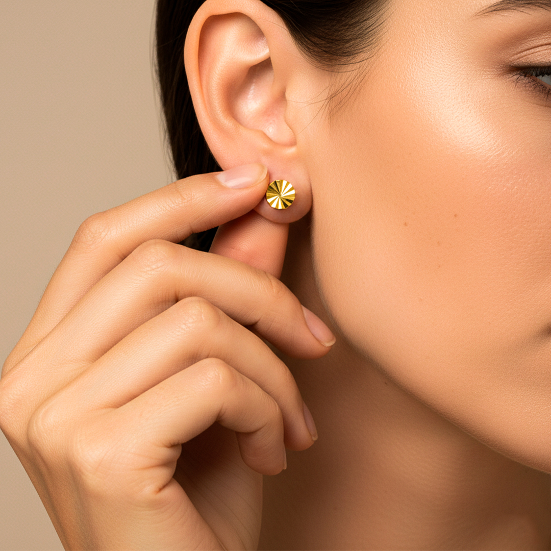 Oreja de modelo usando un topito en forma de rueda diamantada en oro amarillo de 18 quilates de Joyería Caracas. 