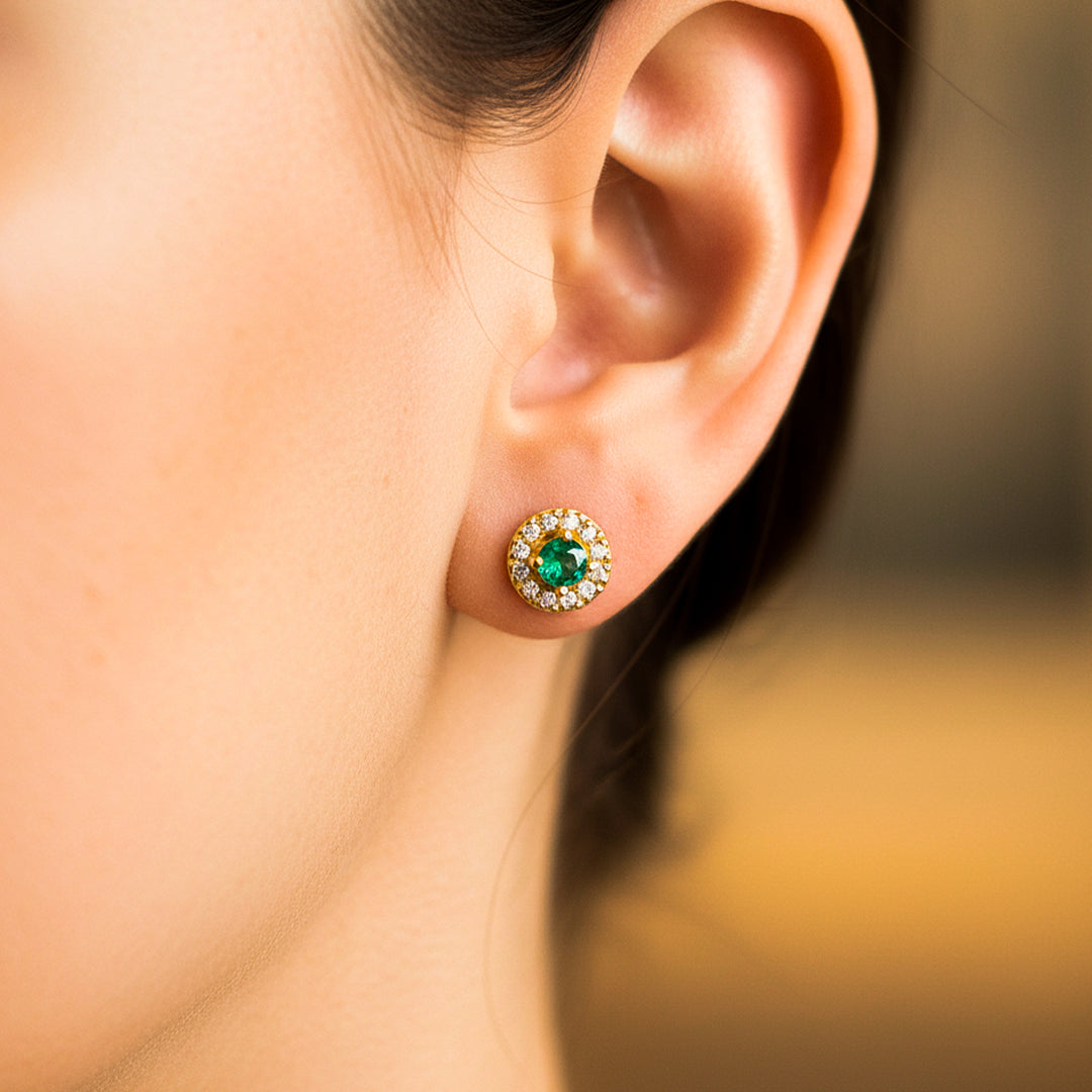 Oreja de modelo usando un topito de rueda en oro amarillo de 18 quilates con Esmeralda y Diamantes de Joyería Caracas.  