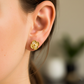 Oreja de modelo usando un topito en forma de trébol en oro amarillo de 18 quilates de Joyería Caracas. 
