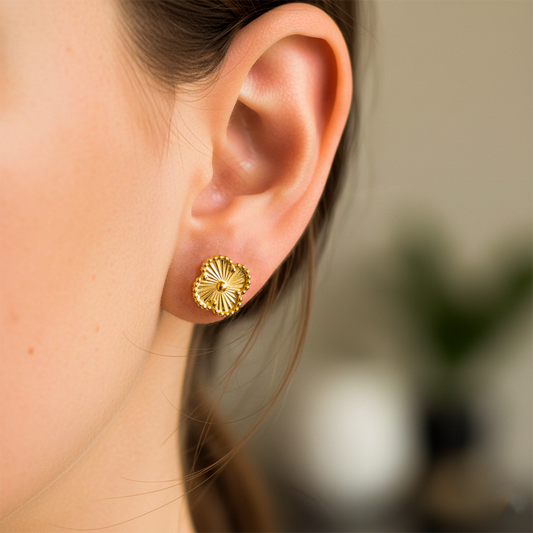 Oreja de modelo usando un topito en forma de trébol en oro amarillo de 18 quilates de Joyería Caracas. 