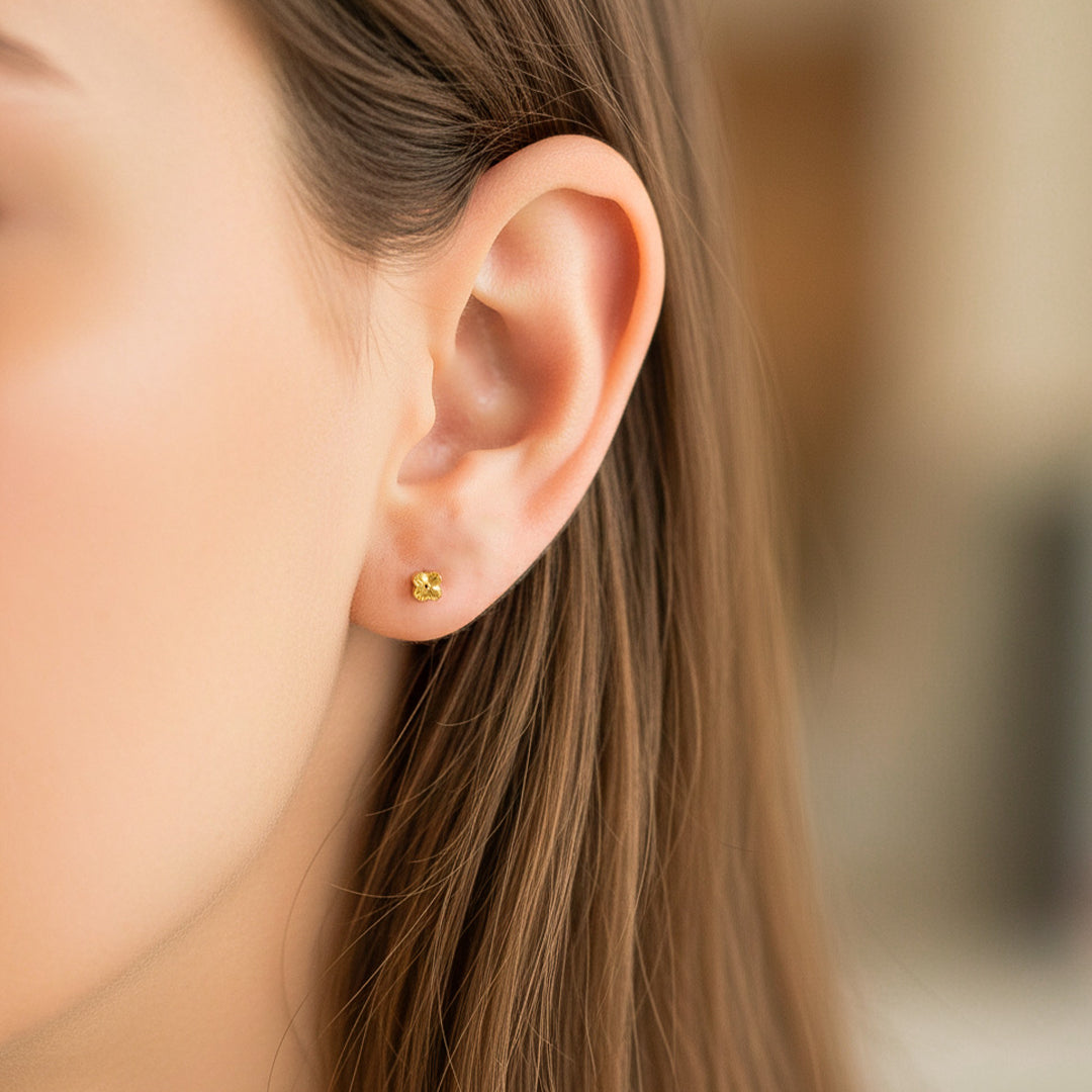 Oreja de modelo usando un topito en forma de trébol en oro amarillo de 18 quilates de Joyería Caracas. 