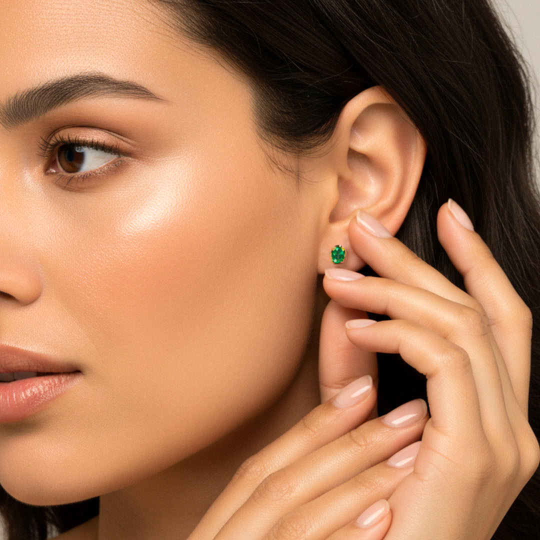 Oreja de modelo usando un topito en oro amarillo de 18 quilates con Esmeralda ovalada de Joyería Caracas. 
