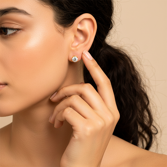 Oreja de modelo usando un topito redondo en oro amarillo de 18 quilates con cristal de color blanco de Joyería Caracas. 